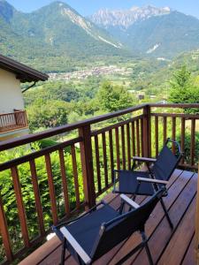 two chairs on a deck with mountains in the background at Casa IBISCO in Tenno