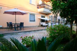 eine Terrasse mit einem Tisch, Stühlen und einem Sonnenschirm in der Unterkunft Casa de Chicca - Cute Apartment near Lake Nemi in Genzano di Roma