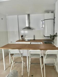 eine Küche mit einem Holztisch und weißen Schränken in der Unterkunft SHERRY SUITES VIII Apartamentos PARKING GRATUITO in Jerez de la Frontera