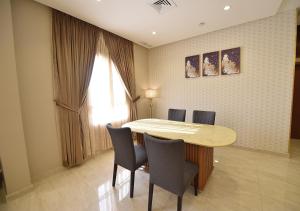 a dining room with a table and chairs and a window at الدرة للشقق الفندقية in Kuwait