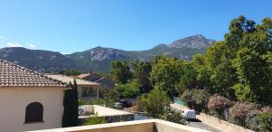 widok na dom z górami w tle w obiekcie Très bel appartement,proche plage et centre ville. w Calvi