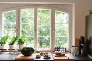 a kitchen with a large window and a table with food at Ferienwohnung in der Villa Sana mit großem Garten in Röfingen