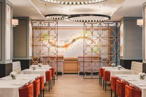 a dining room with tables and chairs and a chandelier at Hotel Budva in Budva