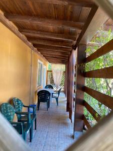 eine Veranda mit Stühlen und einem Tisch in einem Haus in der Unterkunft L’Ortensia in Chia
