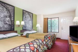 a hotel room with two beds and a flat screen tv at Super 8 by Wyndham Lavonia in Lavonia