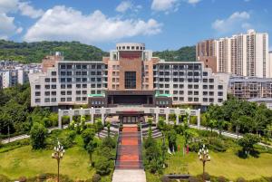 duży budynek z ogrodem przed nim w obiekcie Ramada Plaza by Wyndham Chongqing West w mieście Dazu