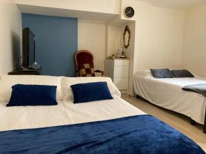 a bedroom with two beds with blue and white at Une chambre chez nous, à 12 minutes de Paris in Malakoff