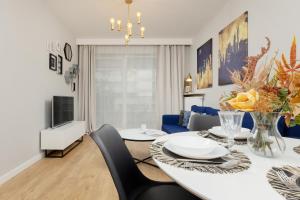 a dining room with a table and a blue couch at Modern Apartment with Balcony Mokotów Business Centre by Renters in Warsaw