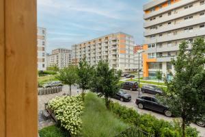 widok na parking z zaparkowanymi samochodami i budynkami w obiekcie Modern Apartment with Balcony Mokotów Business Centre by Renters w Warszawie