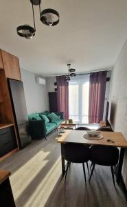 a living room with a table and a green couch at WORKATION Centre Airport Boutique Designer Bath, 3-4 days best offer, Kitchen, Balkony, Aircon in Warsaw