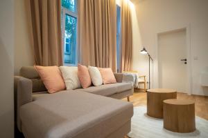 een woonkamer met een bank en 2 tafels bij 2-rooms spacious apartment in a vibrant cozy area in Wenen