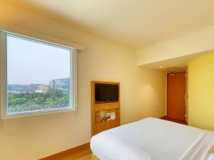 um quarto com uma cama e uma janela em ibis Bengaluru Outer Ring Road em Bangalore
