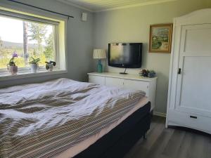 a bedroom with a bed and a flat screen tv at Ytterfalle 169 in Härnösand