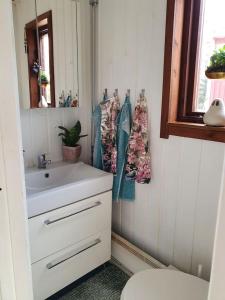 a bathroom with a sink and a toilet and a window at Ytterfalle 169 in Härnösand