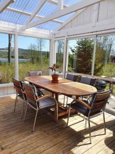 einen Holztisch und Stühle auf einer Holzterrasse in der Unterkunft Ytterfalle 169 in Härnösand