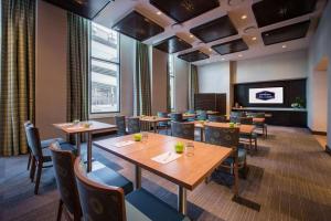 een restaurant met tafels en stoelen en een flatscreen-tv bij Hampton Inn & Suites Washington, D.C. - Navy Yard in Washington