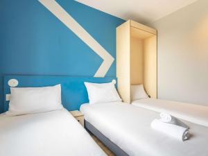 Postel nebo postele na pokoji v ubytování ibis budget Nanterre la Defense