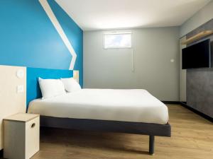 Postel nebo postele na pokoji v ubytování ibis budget Nanterre la Defense