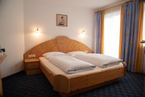 sypialnia z drewnianym łóżkiem z drewnianym zagłówkiem w obiekcie Gasthof Innerwalten w mieście San Leonardo in Passiria