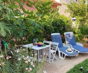 two chairs and a table in a garden at Apartmani Mate in Rogoznica +39 photos