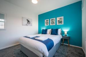 1 dormitorio con 1 cama grande y pared azul en Tranmere House Workstays UK Best Rates Direct, en Middlesbrough