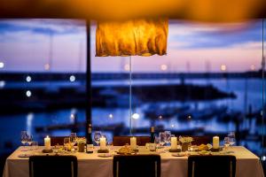 a dining table with candles and chairs and a large window at Octant Ponta Delgada in Ponta Delgada