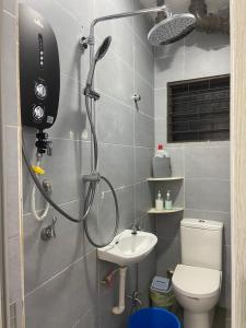 a shower in a bathroom with a toilet and a sink at Hs Homestay Cenderawasih Kuantan Town (5 Bed) in Kuantan