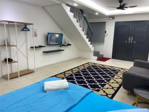 um quarto com uma cama azul e uma escada em Hs Homestay Cenderawasih Kuantan Town (5 Bed) em Kuantan