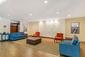 eine Lobby mit zwei blauen Sofas und zwei roten Stühlen in der Unterkunft Comfort Suites At Virginia Center Commons in Richmond