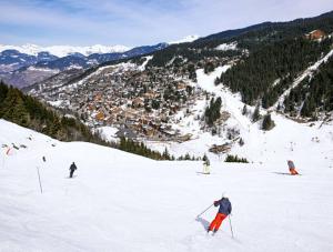 a group of people skiing down a snow covered slope at le plein soleil méribel mottaret in Les Allues