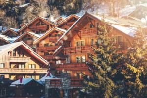 a large wooden house in the snow with a christmas tree at le plein soleil méribel mottaret in Les Allues