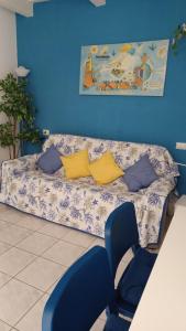 um sofá num quarto com uma parede azul em La Casa di Adele em Porto SantʼElpidio