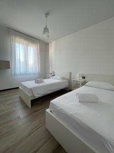 a white room with two beds and a window at Alla Favorita in Bassano del Grappa