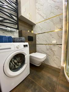 a bathroom with a washing machine and a toilet at apartament u Kasi in Ełk