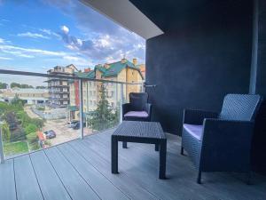 a balcony with two chairs and a table and a large window at apartament u Kasi in Ełk