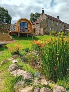 a circular house with a garden in front of it at Coombs glamping pods in Danby