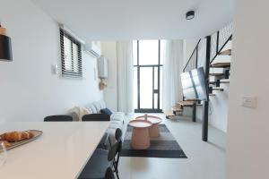 a living room with a table and some chairs at PORT CITY HAIFA - Urbanic Loft in the Heart of Haifa's Downtown in Haifa