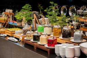 una exposición de plantas en frascos y platos sobre una mesa en Centara Life Maris Resort Jomtien, en Jomtien Beach