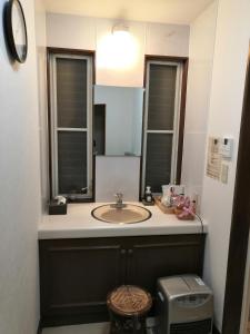 bagno con lavandino e specchio di JOYinn a Ito