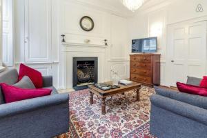 a living room with two couches and a fireplace at Spacious Soho Home On Quaint Cobbled Street in London
