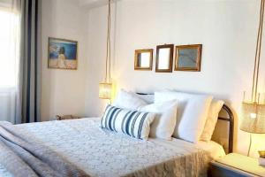 1 dormitorio con 1 cama con sábanas y almohadas blancas en Ammoudara's apartments Rooftop, en Kalymnos