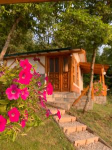 une petite maison avec des fleurs roses devant elle dans l'établissement Sunset House, à Ohrid