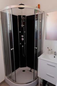 um chuveiro numa casa de banho ao lado de um lavatório em Maison avec jacuzzi 