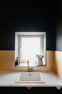 a bathroom with a sink and a window at Maison avec jacuzzi in Montarmin