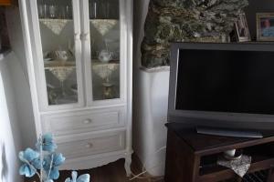 sala de estar con TV y armario blanco en Το Σπίτι του Παππού, en Stení