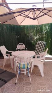 una mesa y sillas bajo una sombrilla en un patio en Apartamento Agradable1, en Madrid