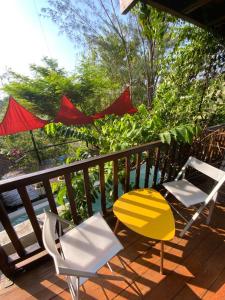 a pair of chairs and a table on a deck at Moemoea Lodge in Ambatoloaka