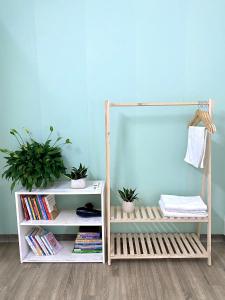 a book shelf with books and potted plants in a room at Green Homestay in Hanoi