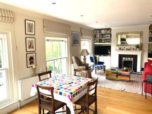 een woonkamer met een tafel en stoelen en een open haard bij Notting Hill Light & Airy in Londen