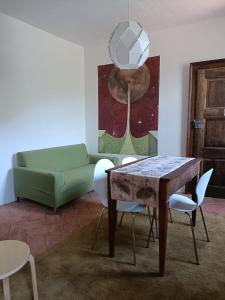 sala de estar con mesa y sofá en La Capinera, en Muggio